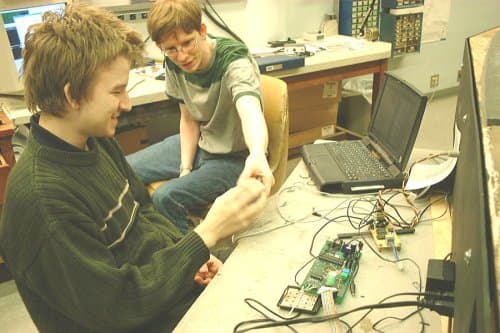 Early programmers collaborating around a terminal.